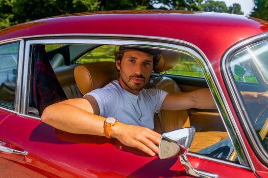 Man in White Polo Shirt Sitting on Red Car Seat