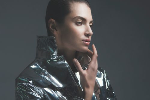 Free Sophisticated portrait of a fashion model in a metallic jacket, captured in a stylish studio setting. Stock Photo