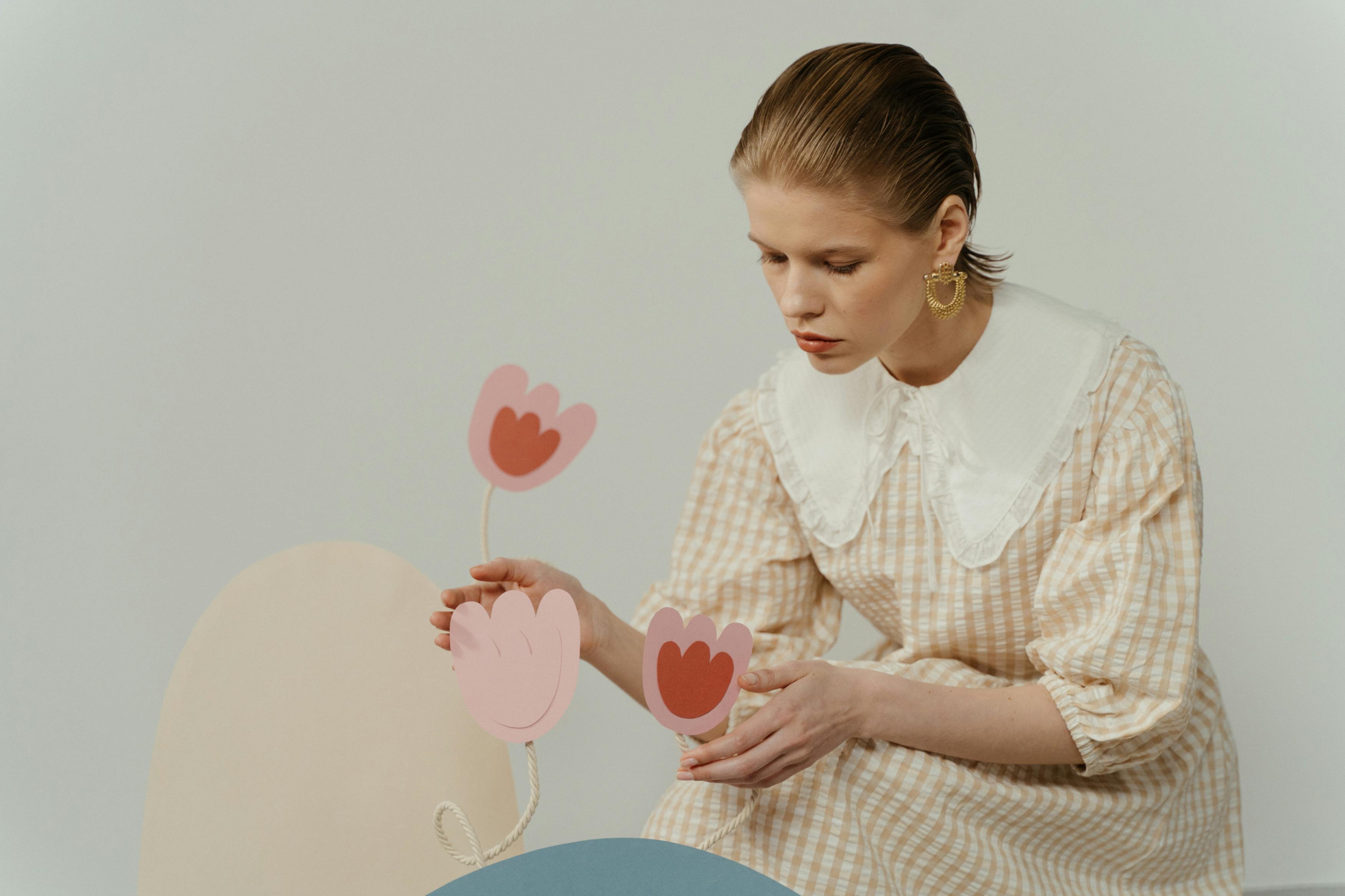 woman in checkered dress holding paper flowers