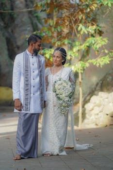 A Sri Lankan couple celebrates their outdoor wedding ceremony in traditional attire, surrounded by nature.