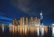 胡志明市的天际线在夜间展现出令人惊叹的景观，灯光明亮的摩天大楼倒映在水中