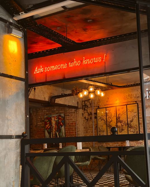 Warm café interior featuring neon sign and rustic decor for relaxed ambiance.