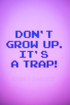 Retro pixel text humorously warns against growing up, on a vivid purple background.