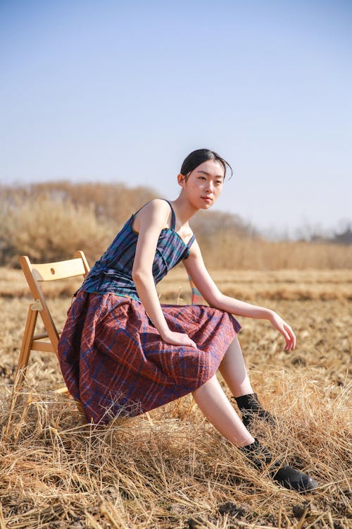 Woman Sitting on a Chair in the Field