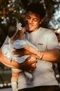 Man in White Crew Neck T-shirt Carrying Baby