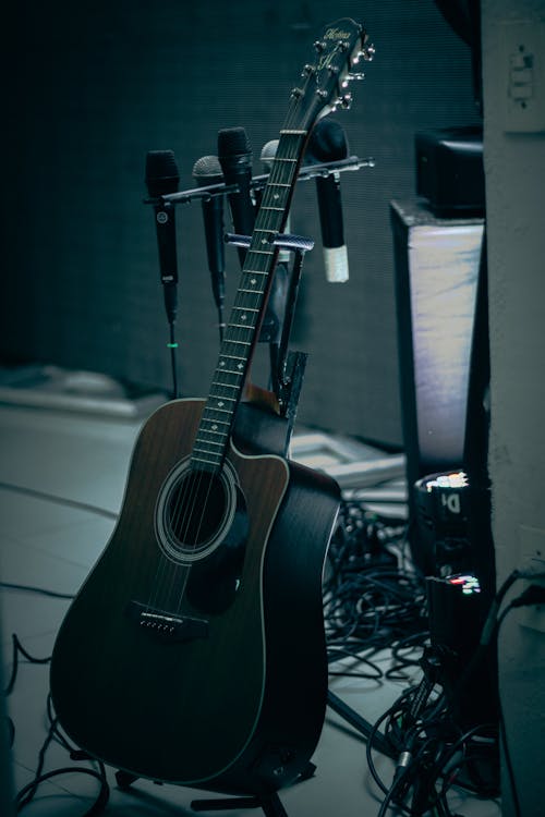 Free Black Acoustic Guitar on Black Guitar Stand Stock Photo