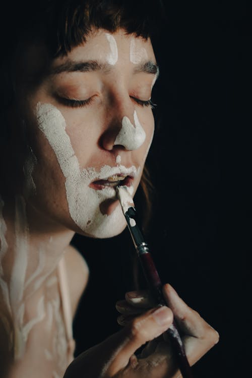 Portrait of a Young Woman Covering Face in White Paint