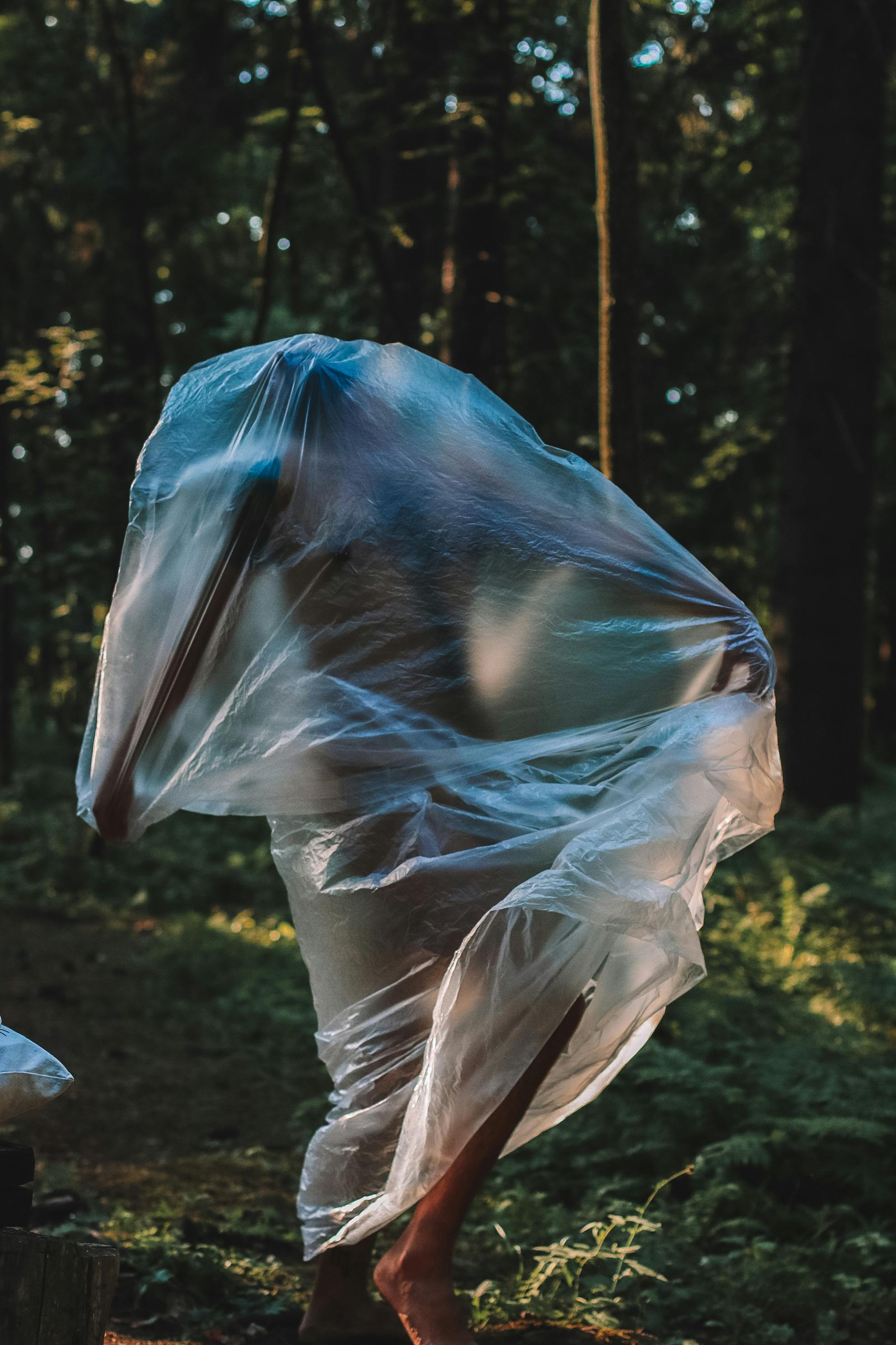 a nude man inside a clear plastic on ground