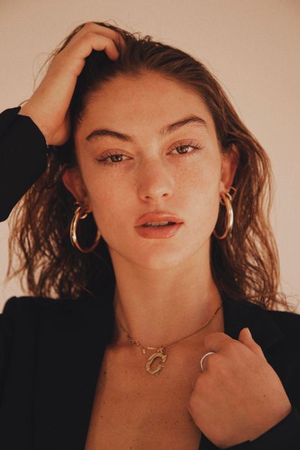 Graceful portrait of a woman with elegant jewelry and soft expression. Perfect for fashion and beauty themes.