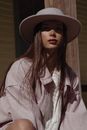 Woman in Pink and White Stripe Long Sleeve Shirt Wearing Black Hat