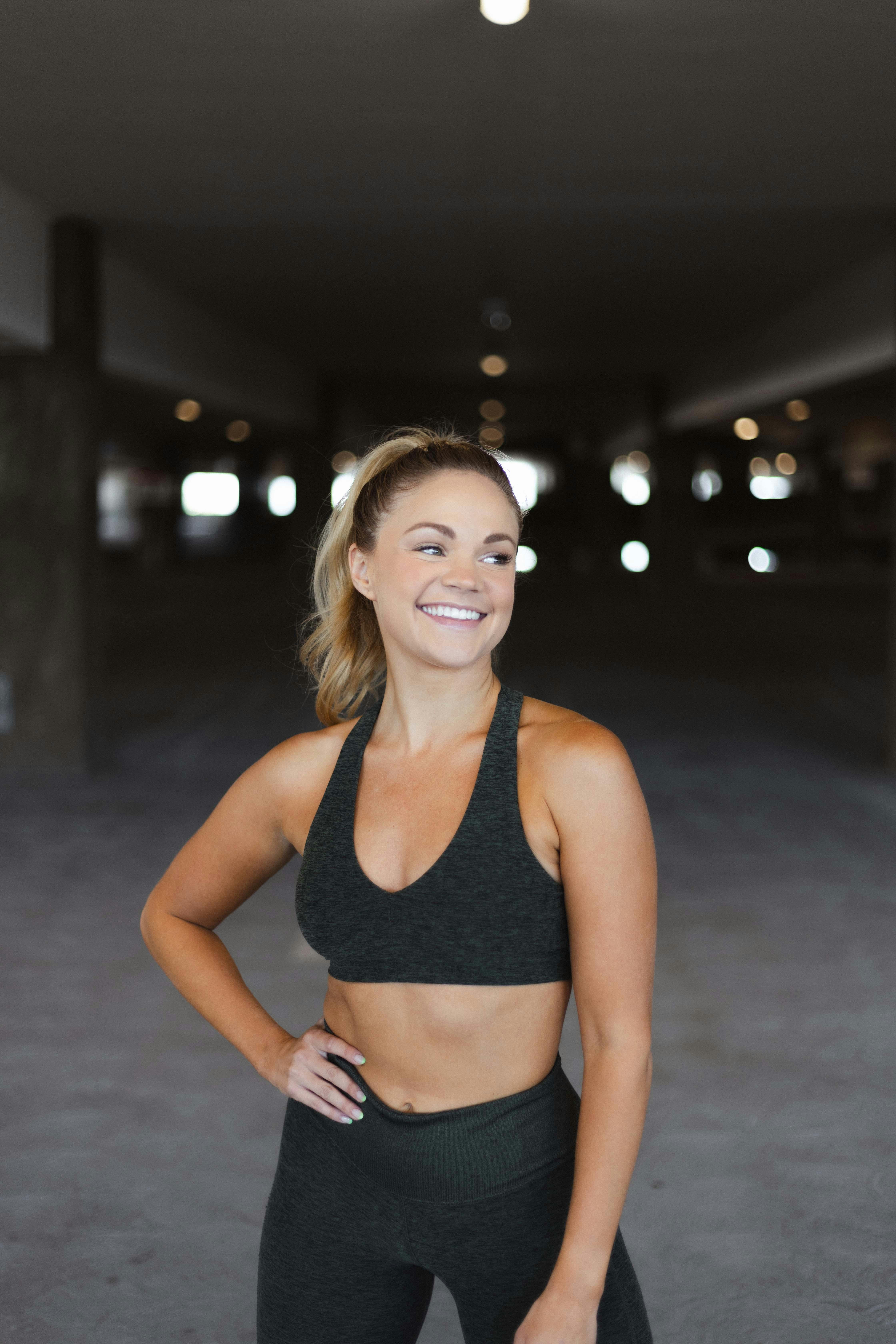 Woman Wearing Sports Bra Standing on Parking Lot · Free Stock Photo