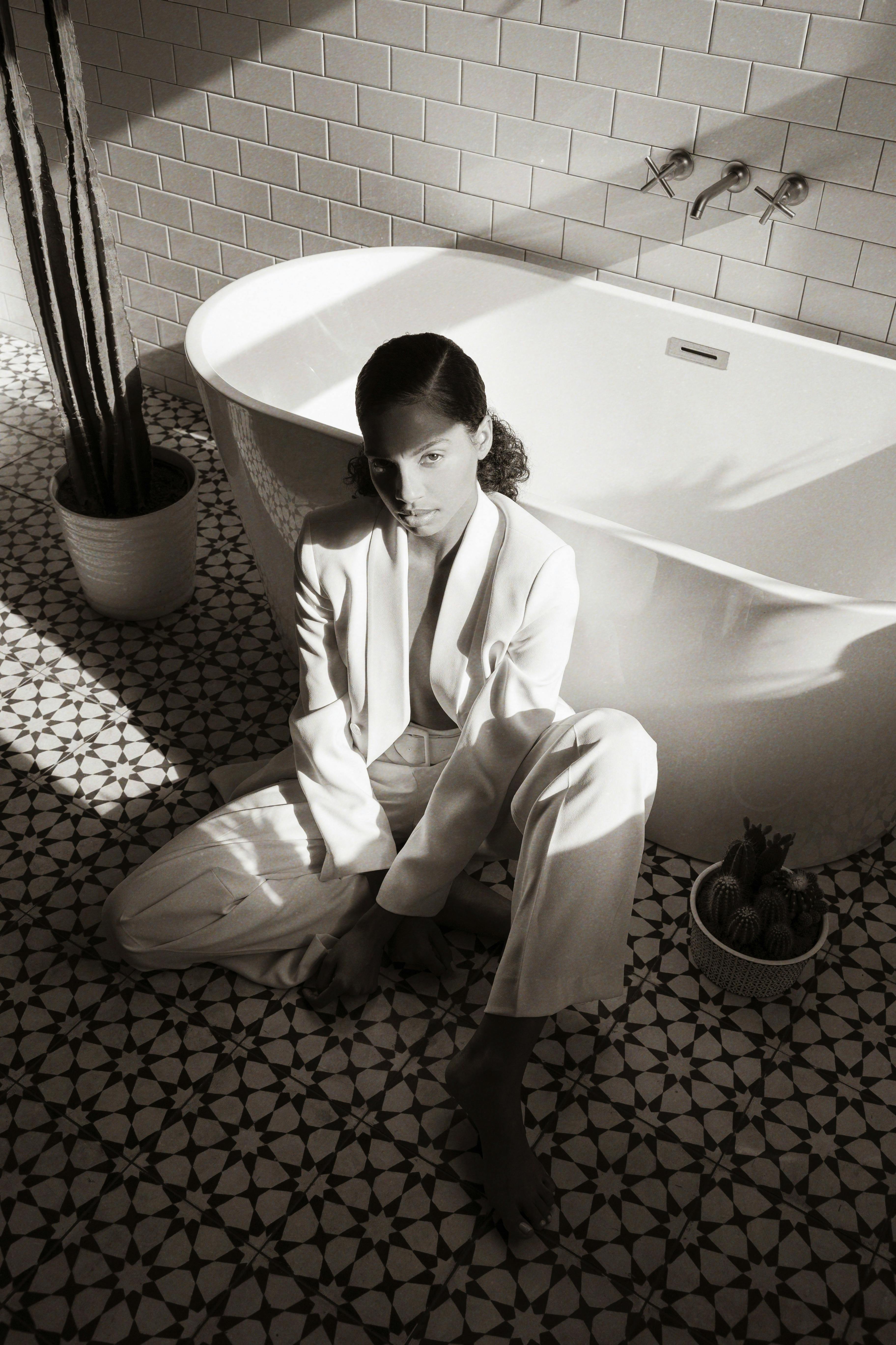 man in white suit sitting on bathtub