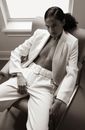 Man in White Suit Sitting on White Wooden Bench