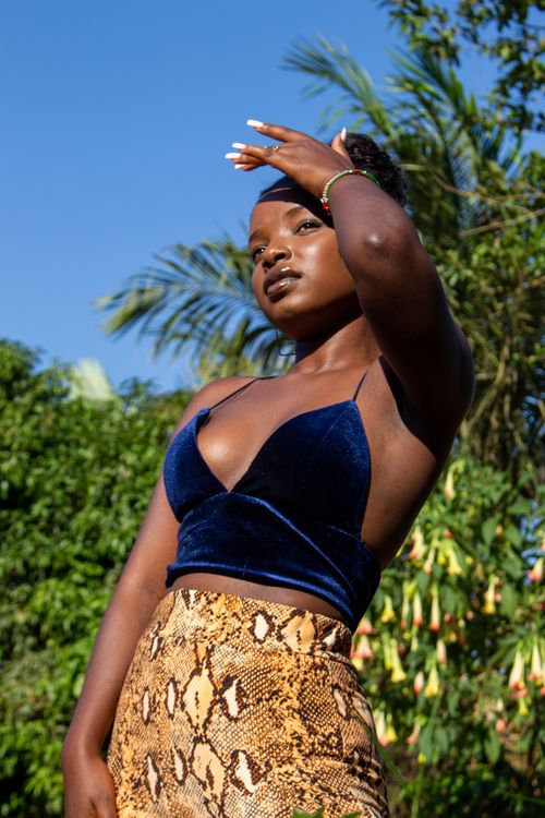 Free Young woman posing stylishly outdoors under clear blue skies. Stock Photo