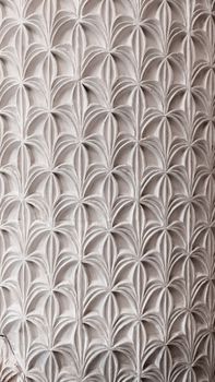 Elegant repeating floral pattern on architectural surface, capturing historic design.