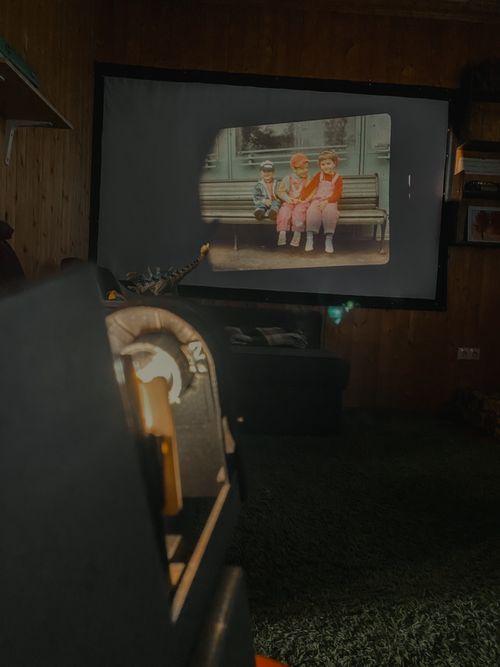 Free Retro film projector displaying nostalgic childhood memories indoors. Stock Photo