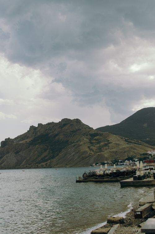 Free A striking view of Koktebel's rocky shore and cloudy sky, capturing nature's raw beauty. Stock Photo