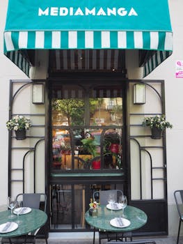 Elegant exterior of a Barcelona cafe with outdoor seating and floral decor.