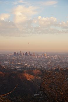 Captivating aerial view of Los Angeles skyline at sunset, highlighting cityscape and natural surroundings.
