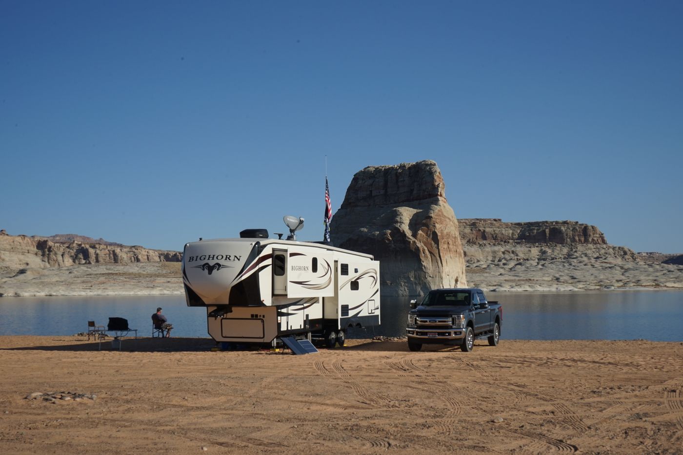 Modern fifth wheel RV at a desert lakeside campsite