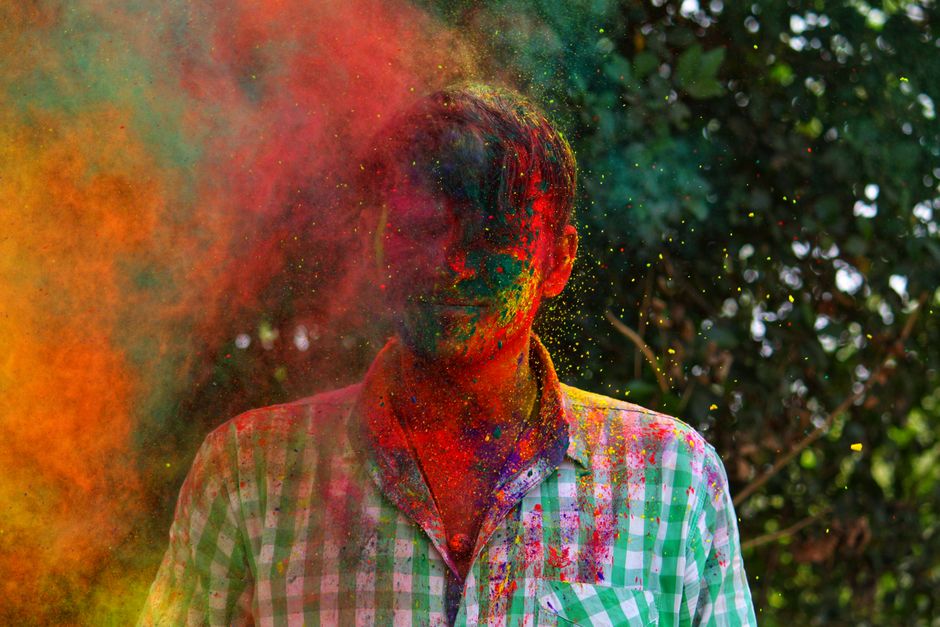 Vibrant portrait of a person celebrating Holi with colorful powder outdoors.