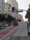 A Tram Moving on the Road Near the Cars Parked on Street