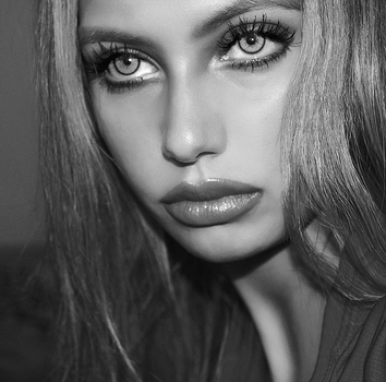 Striking black and white close-up portrait of a woman with captivating eyes and makeup.