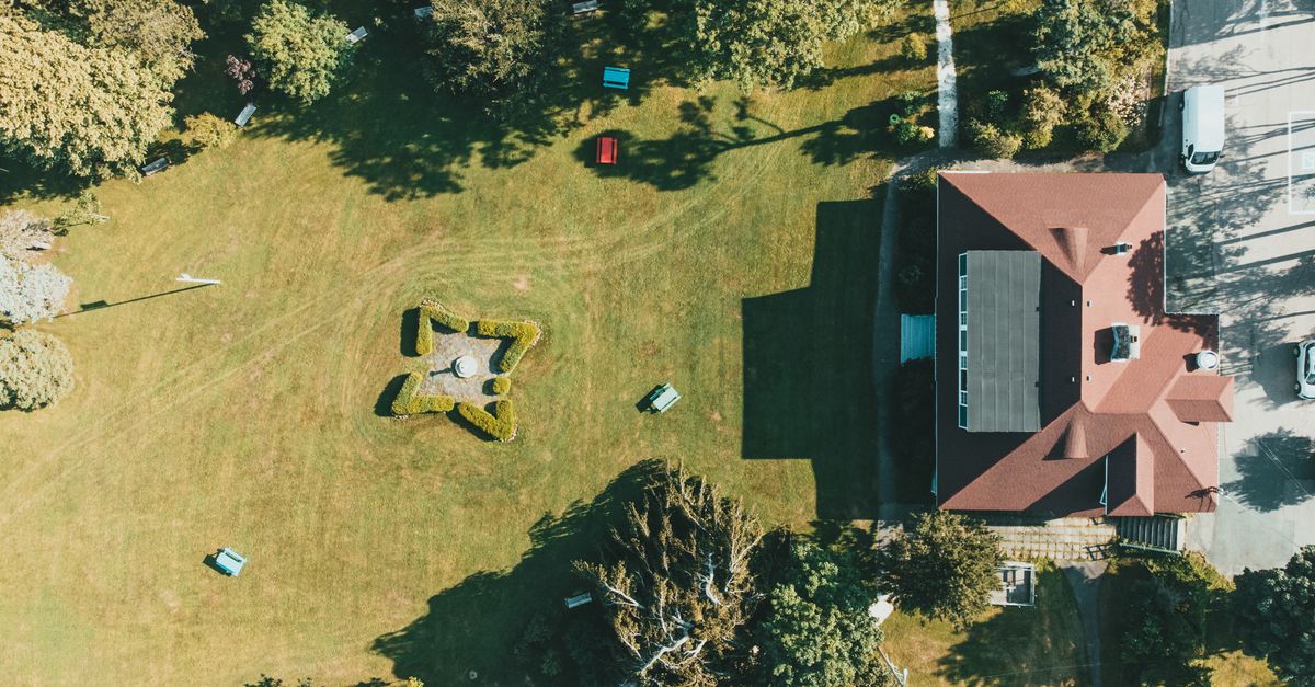 Top-down view of a house with garden and trees, showcasing a summer landscape.