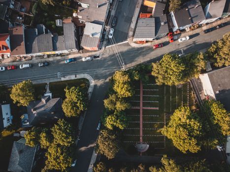 Overhead view of an urban neighborhood with streets, cars, and greenery.