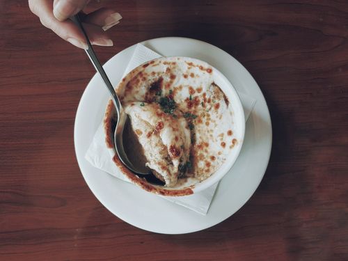 Free Top view of gourmet French onion soup with melted cheese in a ceramic bowl, served with a spoon. Stock Photo