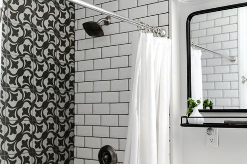 Free Contemporary bathroom featuring patterned and subway tiles with a minimalist mirror and white shower curtain. Stock Photo
