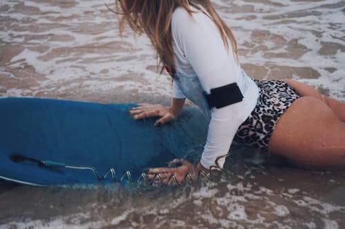 Free Woman Wearing Swimwear Riding a Surfboard Stock Photo