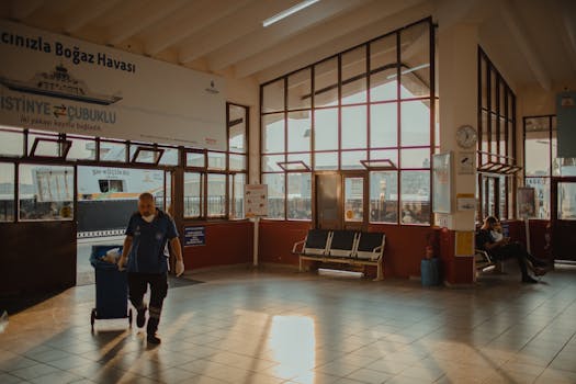 Garbage collector working in a sunlit Istanbul ferry terminal.