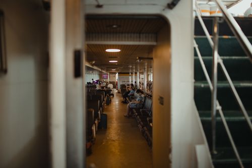 Free Passengers sitting in a hallway on an Istanbul ferry, capturing relaxed travel moments. Stock Photo