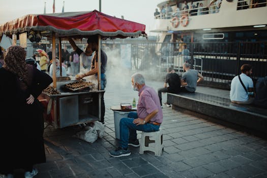 Street food vendor in Istanbul serving customers at the harbor with a bustling atmosphere.
