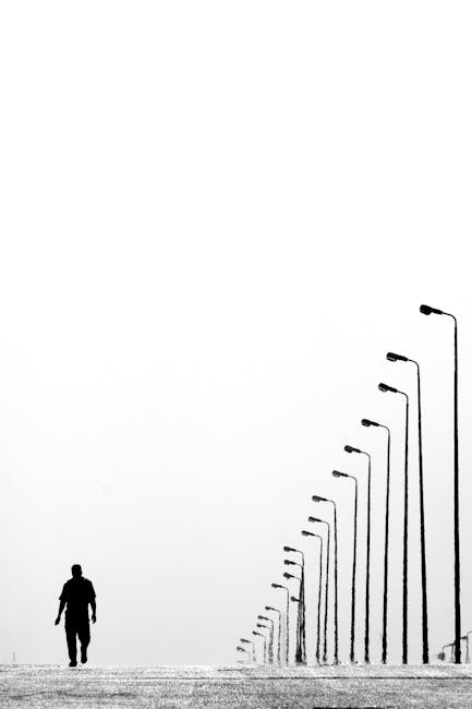 Man Walking Near Aligned Lamp Post