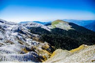 蓝天之下，白雪皑皑的山脉与森林令人惊叹，尽显大自然的壮美