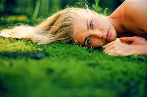 Close-Up Shot of a Woman Lying on Green Grass