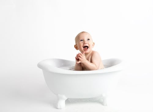 Free Baby Inside White Bathtub With Water Stock Photo