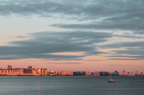 Free Serene view of St. Petersburg skyline with dramatic clouds and a sailboat at sunset. Stock Photo