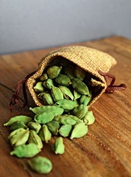Green cardamom pods spilling from a linen sack — Nidhin K S on Pexels