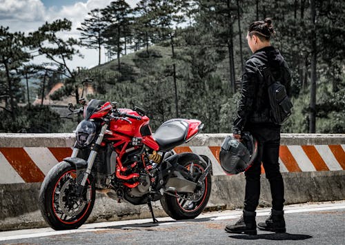 Man Looking at Red Motorcycle