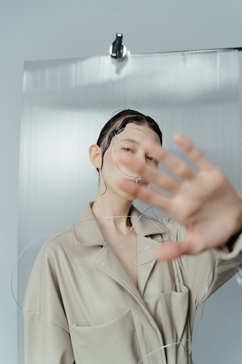 Free Woman in Beige Coat Covering Her Face With Her Hands Stock Photo
