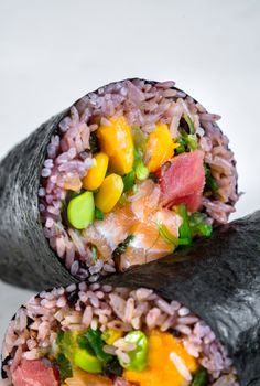 Close-up of a vibrant sushi burrito with fresh veggies and seafood.