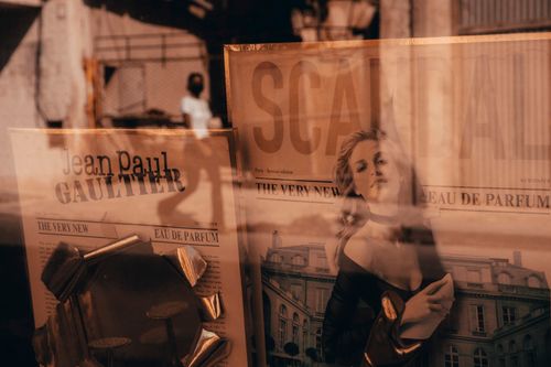 Free Elegant window display with reflection of Havana's streets showcasing Jean Paul Gaultier perfume. Stock Photo