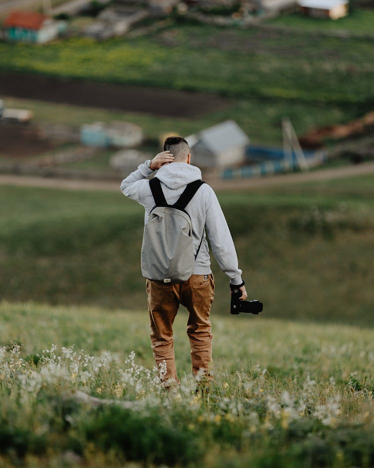 A Person With A Back Pack Holding A Camera