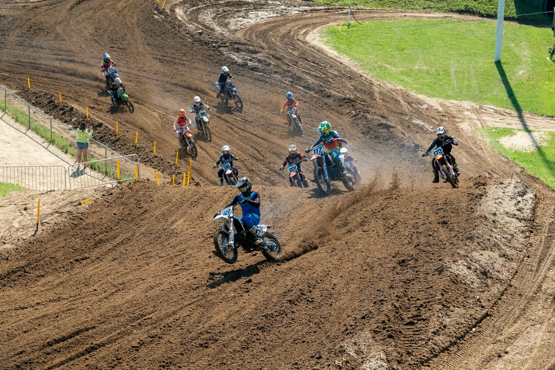 High-intensity motocross race on a dirt track in Millville, MN with skilled riders in action.