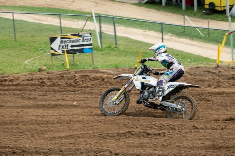 A Man Riding Motocross Dirt Bike On The Race Track