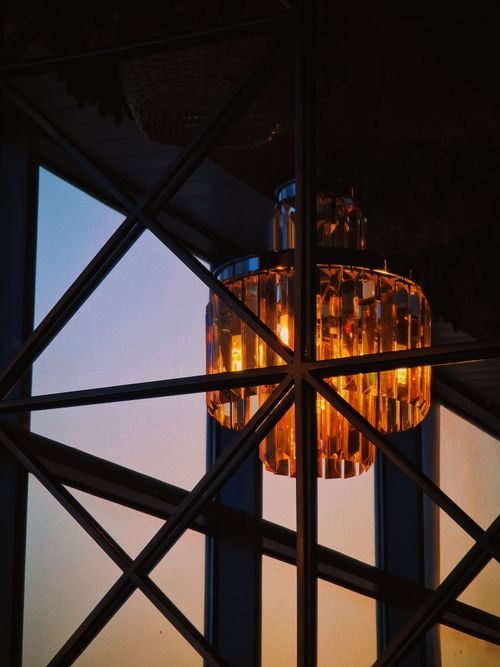 Free Illuminated chandelier reflecting the sunset in Краснодар, Russia, creating a warm and decorative ambiance. Stock Photo