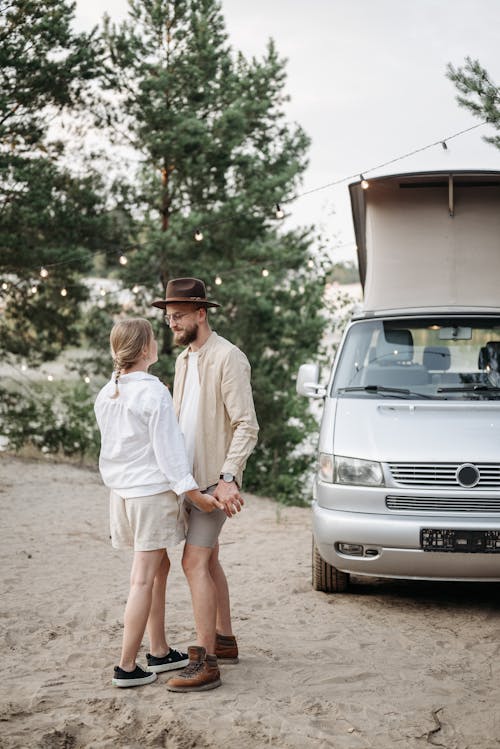 A Couple Standing Beside the Campervan